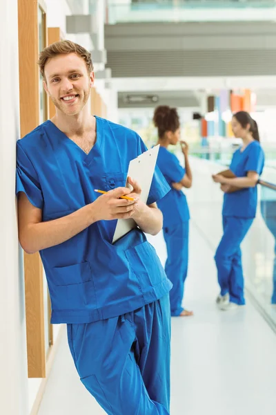 Studente medico sorridente alla macchina fotografica nel corridoio — Foto Stock