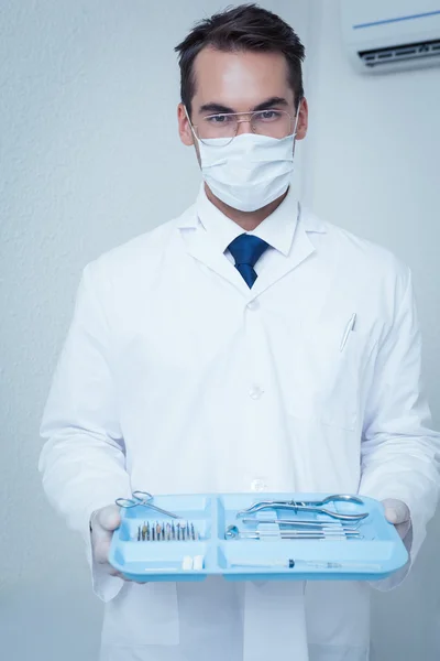 Männlicher Zahnarzt in chirurgischer Maske mit Tablett voller Werkzeuge — Stockfoto