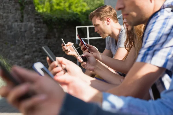 Glada studenter sitter i en rad textning — Stockfoto