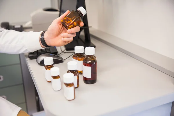 Pharmacist holding jar of medicine — Stock Photo, Image