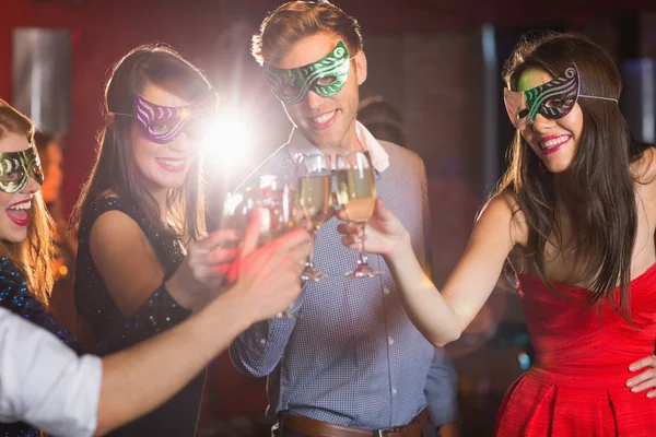 Amis aux masques de mascarade trinquant au champagne — Photo