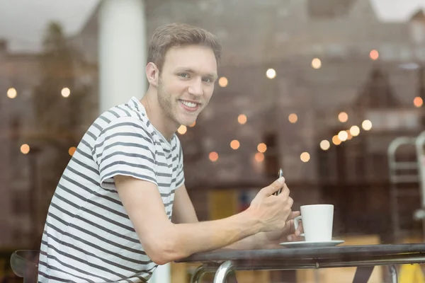 Usměvavý student sedí s horkým nápojem — Stock fotografie