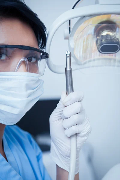 Dentist in surgical mask holding dental drill — Stock Photo, Image