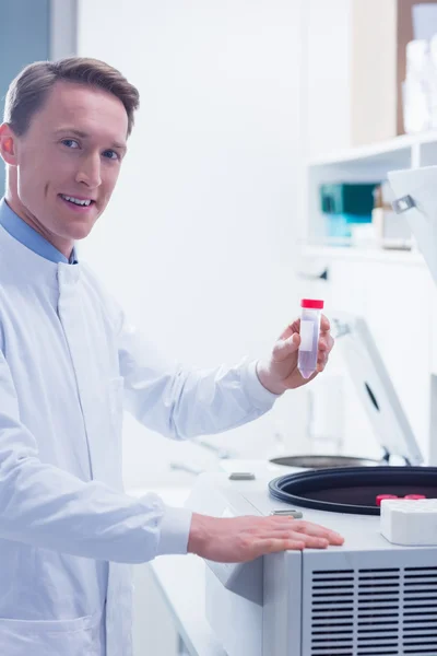 Lächelnder Chemiker mit Reagenzglas — Stockfoto