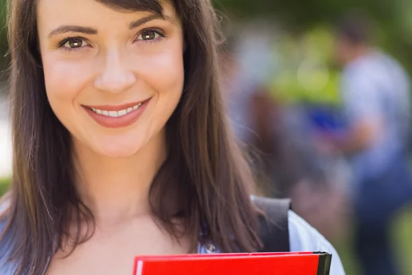 Ładny studenta uśmiecha się do kamery na zewnątrz na kampusie — Zdjęcie stockowe