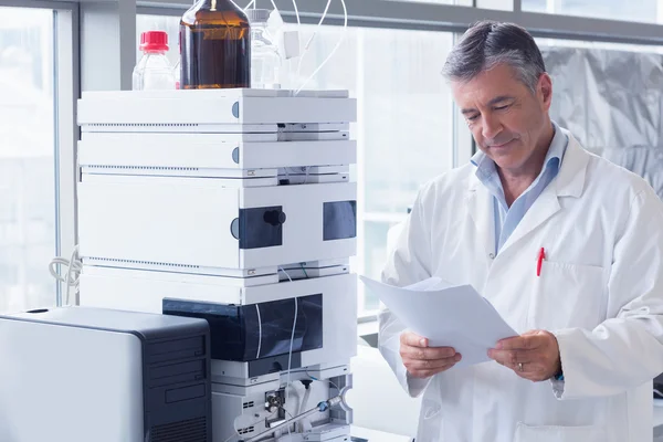 Scientifique debout dans l'analyse de lecture de blouse de laboratoire — Photo