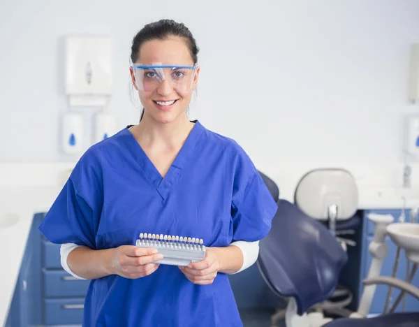 Dentista con occhiali di sicurezza che tengono i denti sbiancanti — Foto Stock