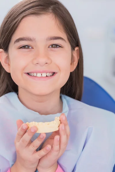 Sorrindo jovem paciente segurando dentes — Fotografia de Stock