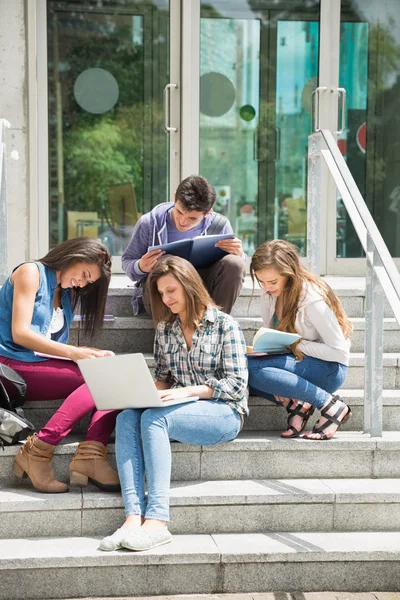 Studenti seduti su gradini a studiare — Foto Stock