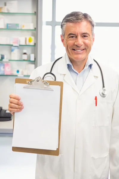 Happy pharmacist showing page on clipboard — Stock Photo, Image