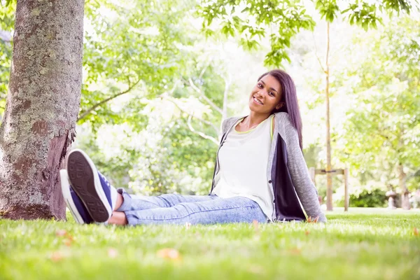 Jolie brune souriant à la caméra dans le parc — Photo