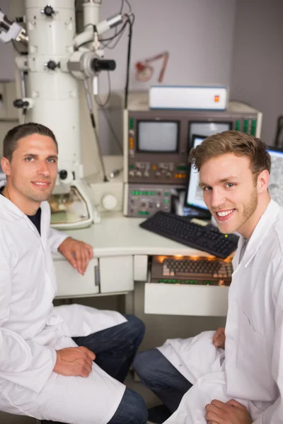 Biokemi student med stora mikroskopet — Stockfoto