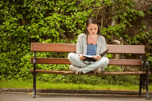 Étudiant assis sur le banc écouter de la musique avec téléphone mobile et r — Photo