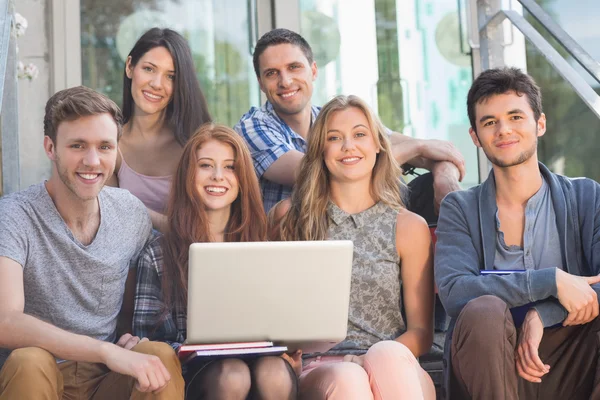 Glada studenter ler mot kameran utanför på campus — Stockfoto