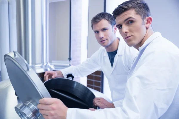 Dois cientistas abrindo a tampa e olhando para a câmera — Fotografia de Stock