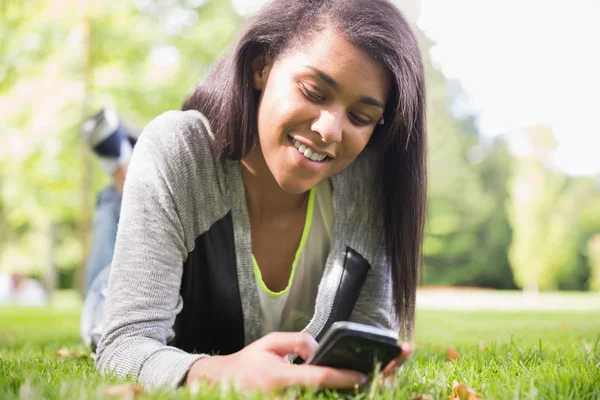 Bella bruna usando il suo smartphone nel parco — Foto Stock