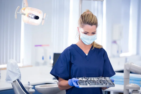 Стоматолог в маске держит поднос с инструментами — стоковое фото