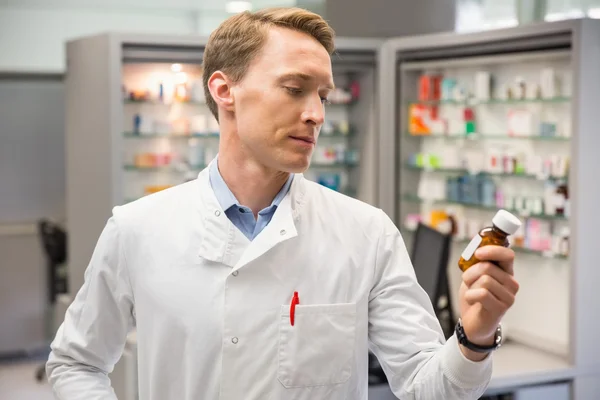 Bel farmacista che guarda la medicina — Foto Stock