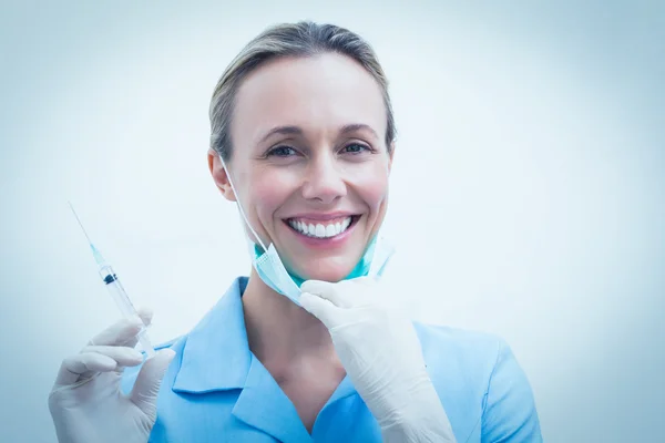 Dentista sorridente segurando injeção — Fotografia de Stock