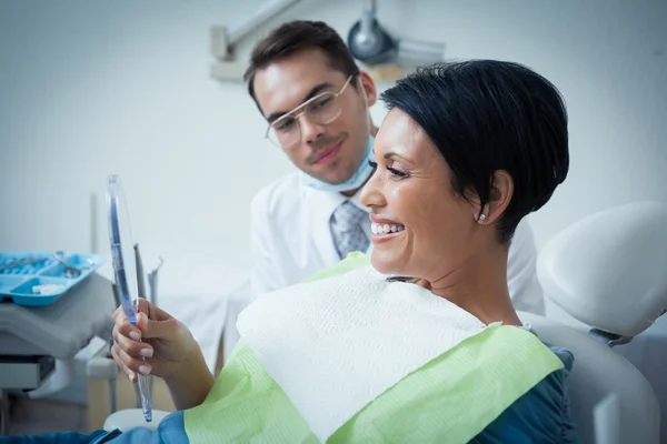 Vista laterale della paziente sorridente con dentista — Foto Stock