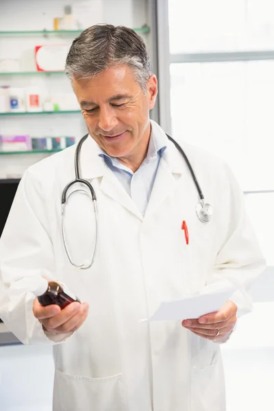 Счастливый фармацевт держит банку с лекарствами — стоковое фото