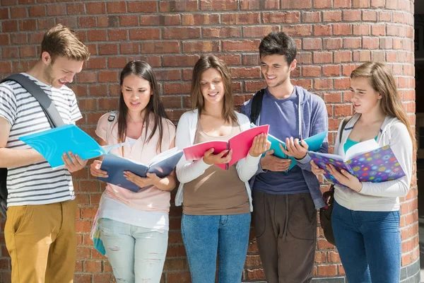 Happy students standing and reading Stock Image