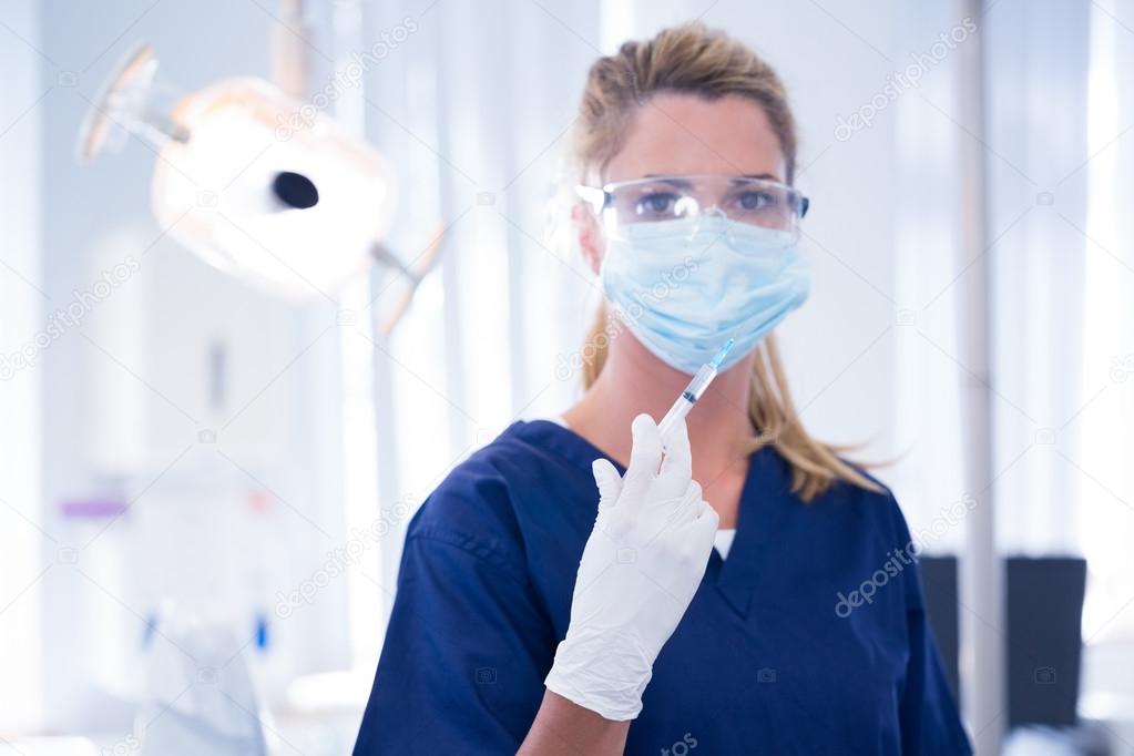 Dentist in mask and glove holding an injection — Stock Photo