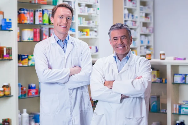 Farmacêuticos sorridentes de pé de braços cruzados — Fotografia de Stock