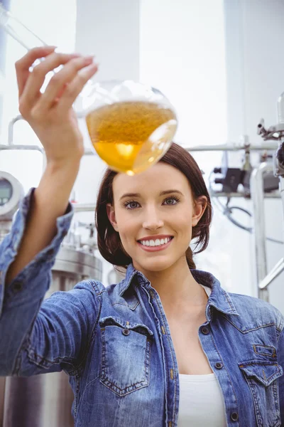 Kvinna som tittar på kameran medan du håller bägare öl — Stockfoto