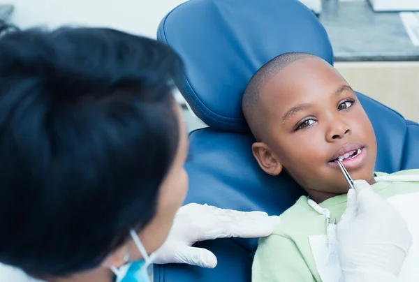 Стоматолог вивчає зуби хлопчиків у стоматологічному кріслі — стокове фото
