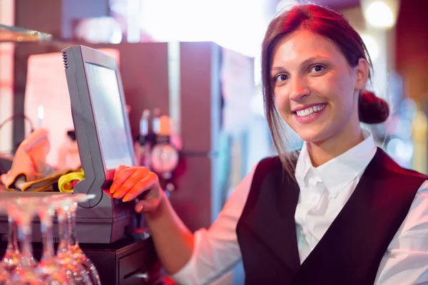 Happy barmaid using touchscreen till — Stock Photo, Image