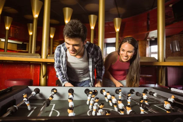 Amici sorridenti che giocano a calcio balilla insieme — Foto Stock