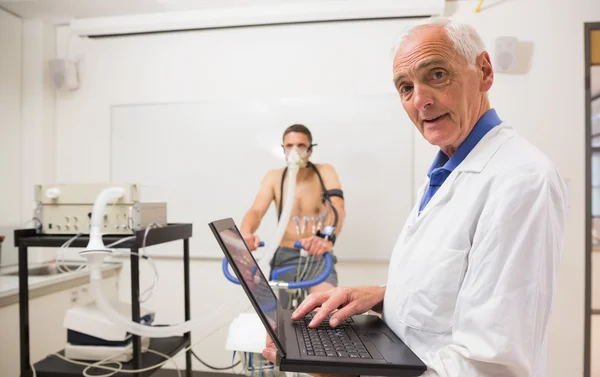 Médico realizando prueba de aptitud sonriendo a la cámara — Foto de Stock