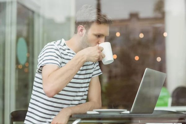 Smiling student drinking hot drink — Stock Photo, Image