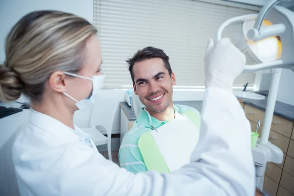 Vrouwelijke tandarts onderzoeken mans tanden — Stockfoto
