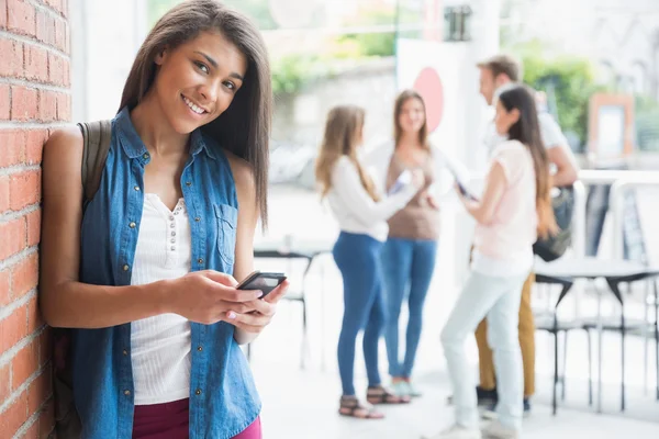 Hübsche Studentin lächelt in die Kamera mit Mitschülern im Hintergrund — Stockfoto