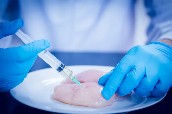 Científico alimentario inyectando pollo crudo —  Fotos de Stock