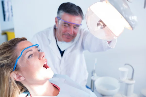 Tandarts onderzoeken een patiënten tanden — Stockfoto