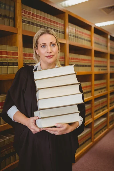 Abogado sosteniendo pesada pila de libros de pie —  Fotos de Stock