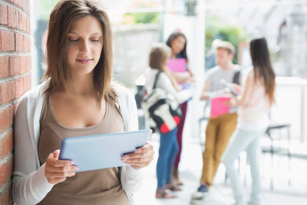 Hübsche Studentin lächelt und hält Tablet in der Hand — Stockfoto