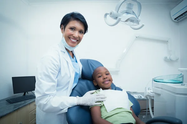 Portret van lachende vrouwelijke tandarts jongens tanden te onderzoeken — Stockfoto
