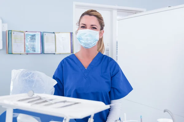 Стоматолог в маске за подносом инструментов — стоковое фото
