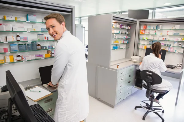 Farmacêutico feliz usando o computador — Fotografia de Stock