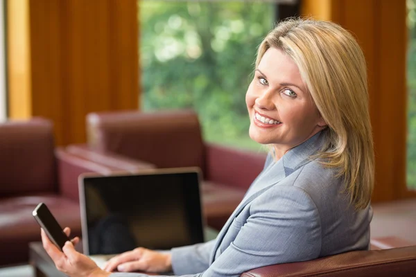 Blonde Geschäftsfrau benutzt ihr Handy — Stockfoto