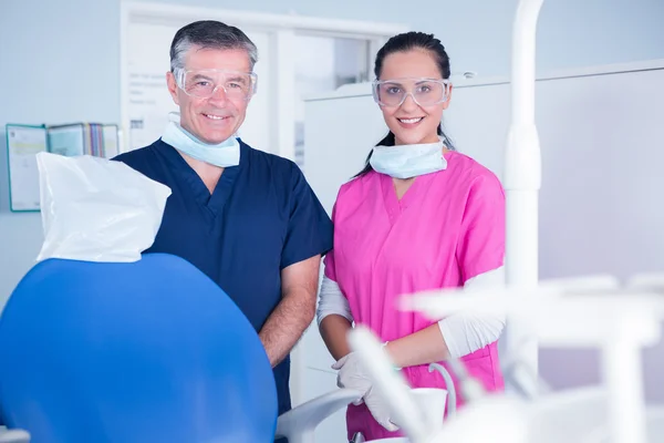 Dentista e assistente com óculos de proteção — Fotografia de Stock