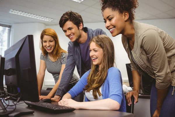 Χαμογελώντας μαθητές να κάθονται στο γραφείο που χρησιμοποιούν τον υπολογιστή μαζί — Φωτογραφία Αρχείου