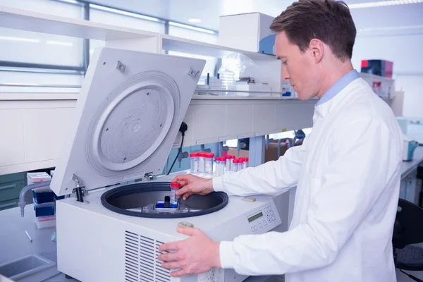 Químico en bata de laboratorio usando una centrifugadora —  Fotos de Stock