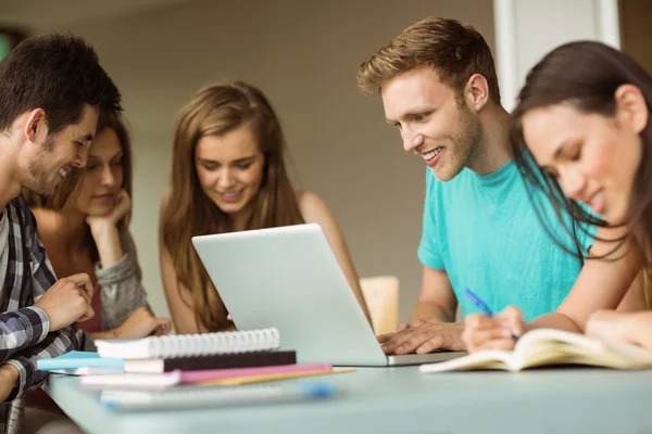 Lachende vrienden zitten studeren en met laptop — Stockfoto