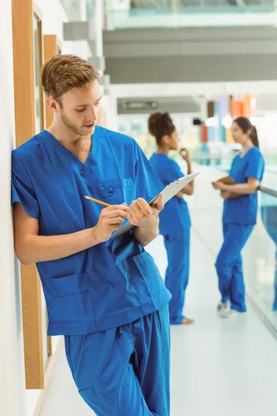 Läkarstuderande göra anteckningar i korridoren — Stockfoto