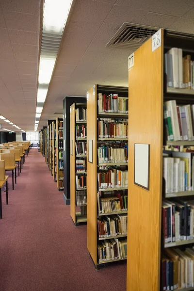 Svazky knih na polici v knihovně — Stock fotografie